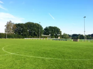 Veld met middencirkel op Sportpark Dèl-Akker onder een blauwe lucht